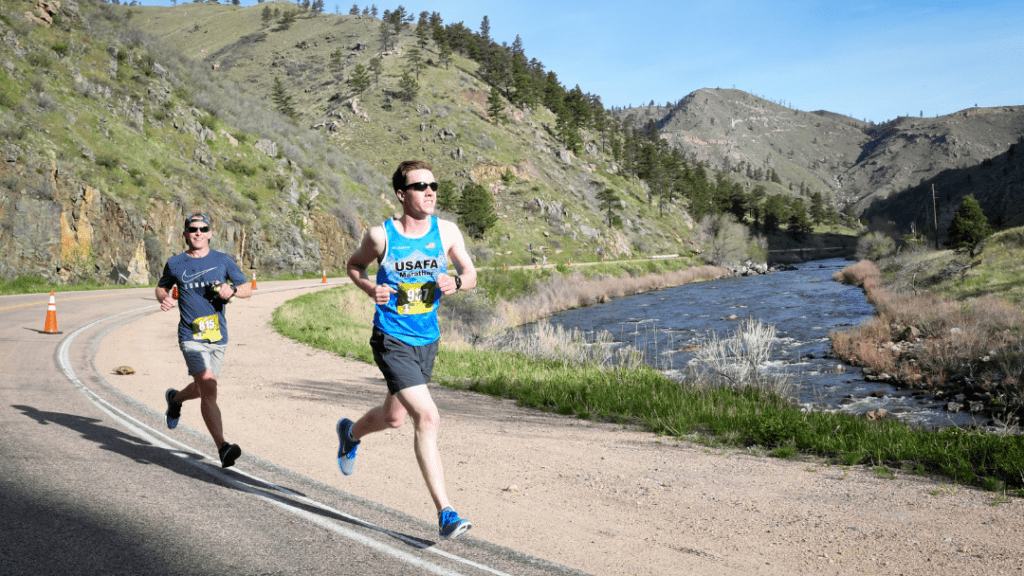 Two male runners running a downhill marathon in Colorado