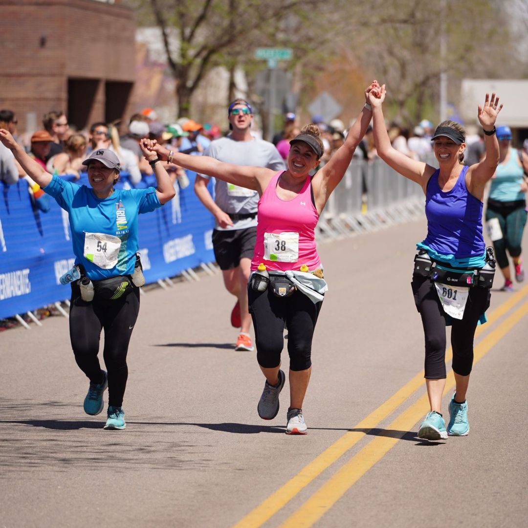 Three female runners finishing the Colorado Marathon