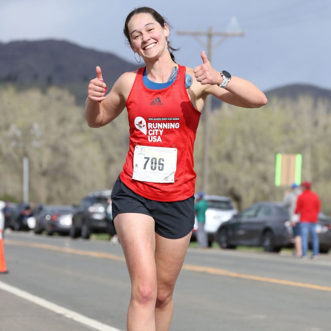 Smiling female runner shows how easy it is to register for the Colorado Marathon